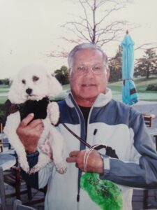 An old man holding his dog in hand