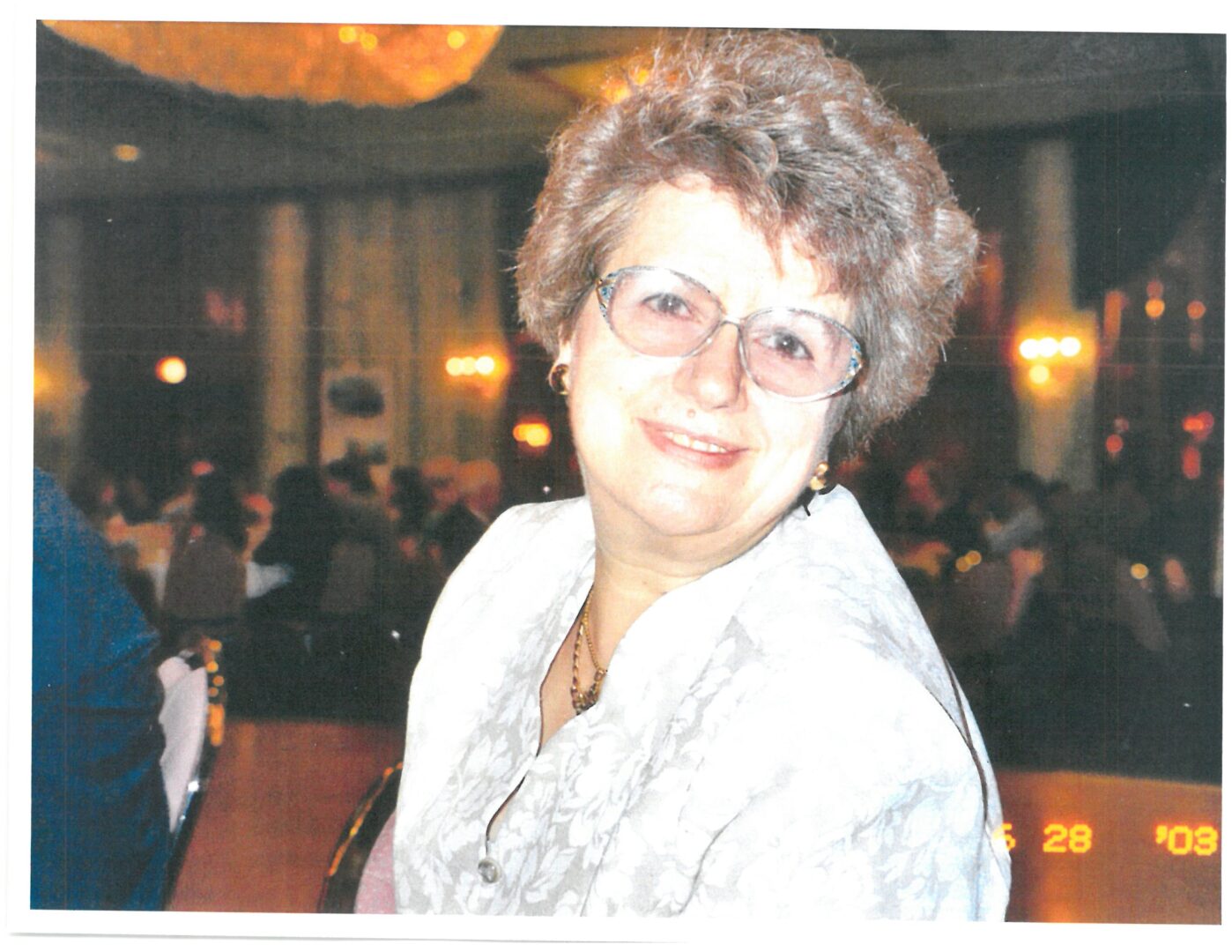 An old woman with curly hairs smiling at the camera
