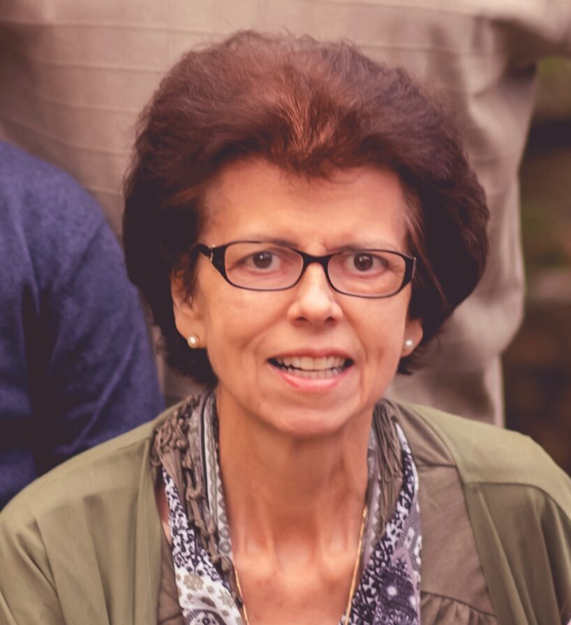 A woman in glasses is smiling for the camera.