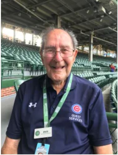 An old man wearing a tshirt smiling at the camera