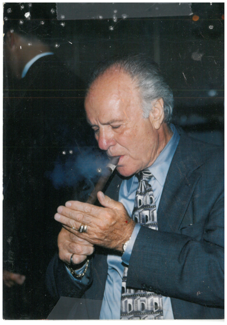A man in a suit smoking a cigar.