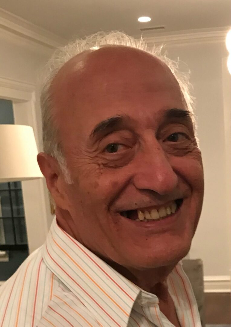 A man in a striped shirt smiles for the camera.