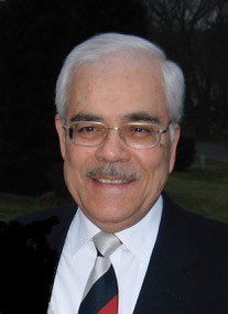A man in a suit and tie smiles for the camera.