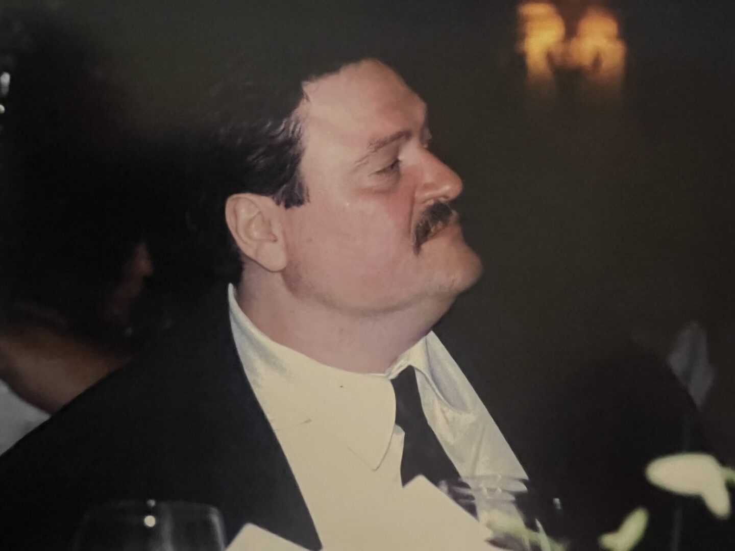 A man in a tuxedo sitting at a table.