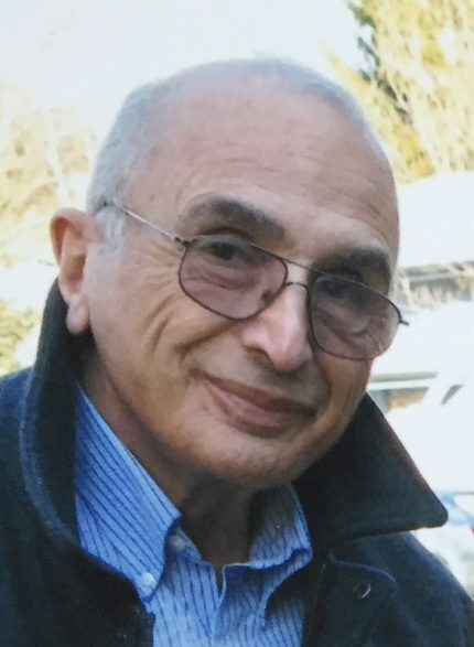 An older man wearing glasses and a jacket.