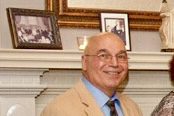 Man smiling at a formal event.