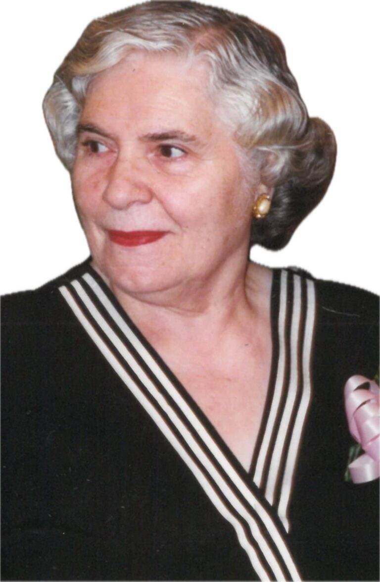 Elderly woman with white hair and red lipstick smiling slightly.