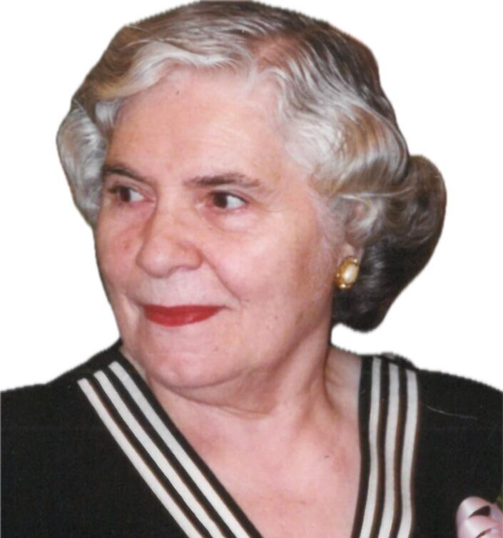 Elderly woman with white hair and red lipstick smiling slightly.