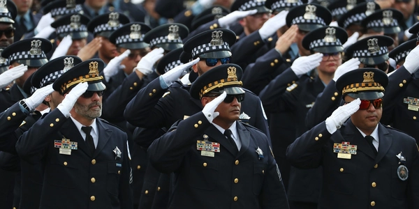 A group of uniformed officers saluting at a formal event.