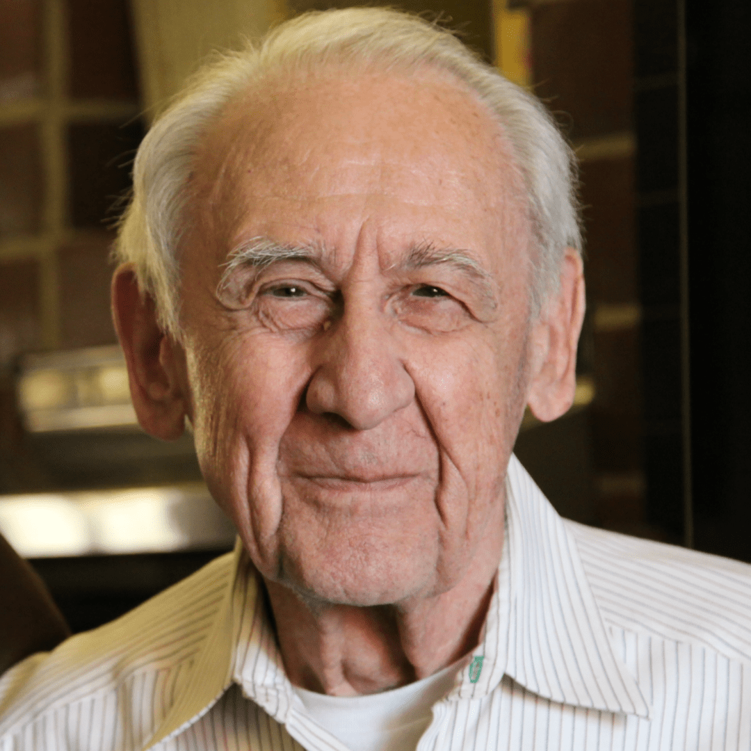 Smiling elderly man in striped shirt.