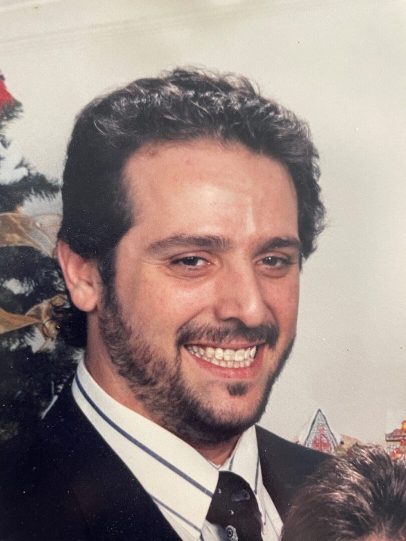 A smiling man with a beard posing for a photo.